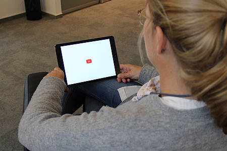 Frau schaut Youtube auf einem Tablet