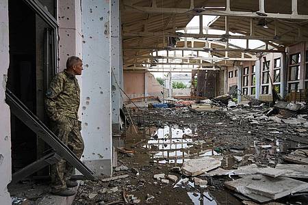 Ein ukrainischer Soldat betrachtet die Ruinen des Sportkomplexes der Nationalen Technischen Universität in Charkiw, der während eines nächtlichen Beschusses beschädigt wurde
