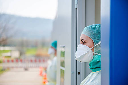 Krankenhaus-Mitarbeiter guckt aus Fenster