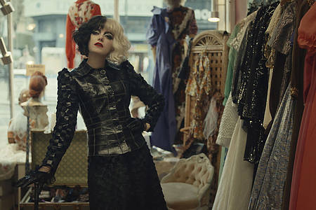 Cruella-Darstellerin Emma Stone vor einer Kleiderstange