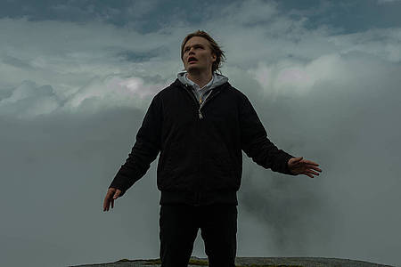 Mann vor dunklen Wolken